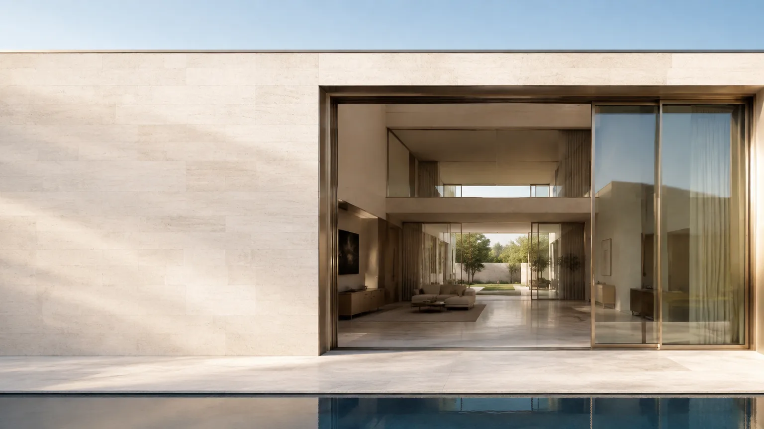 Limestone courtyard house with a champagne aluminum glazed opening beside a reflecting pool