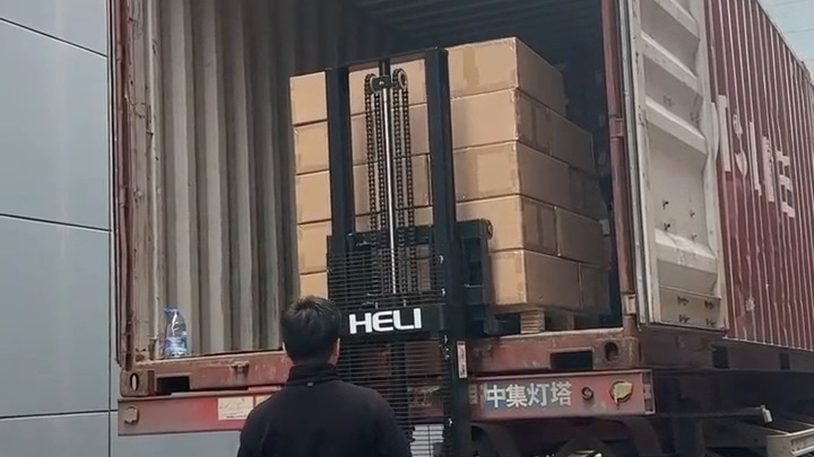 Packed boxes and pallet jack at a container door