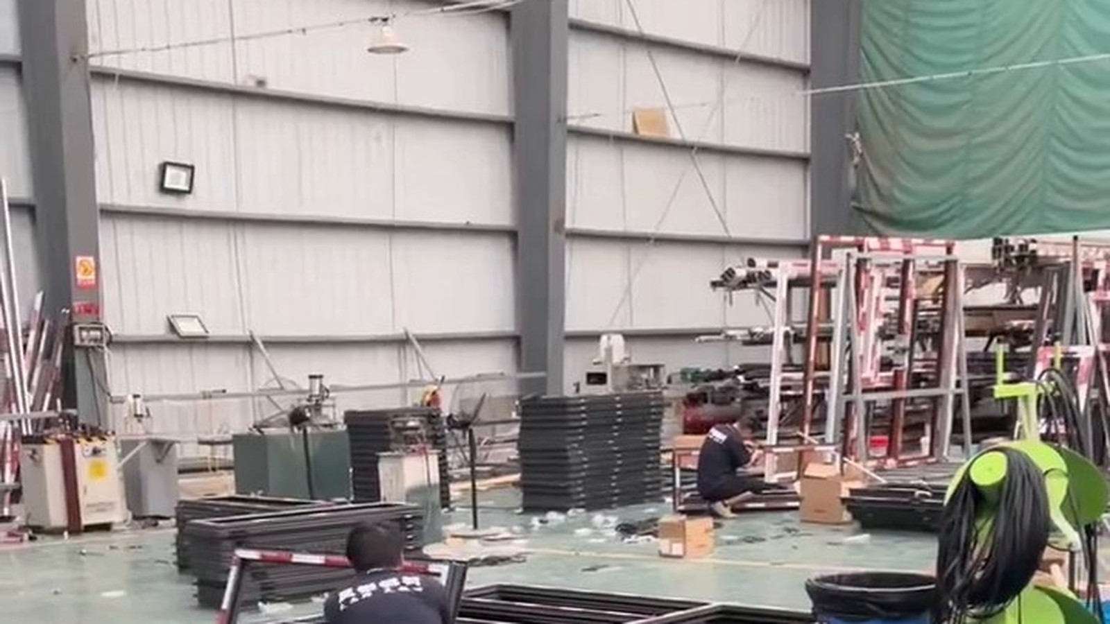 Factory workers assembling batches of aluminum frames